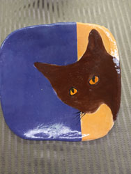 ceramic plate brown cat with peach and purple background